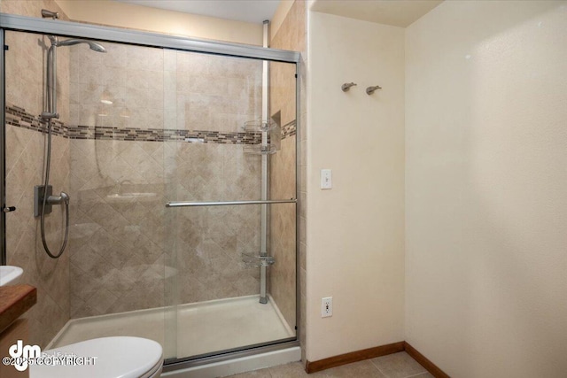 bathroom with toilet, tile patterned flooring, an enclosed shower, and vanity