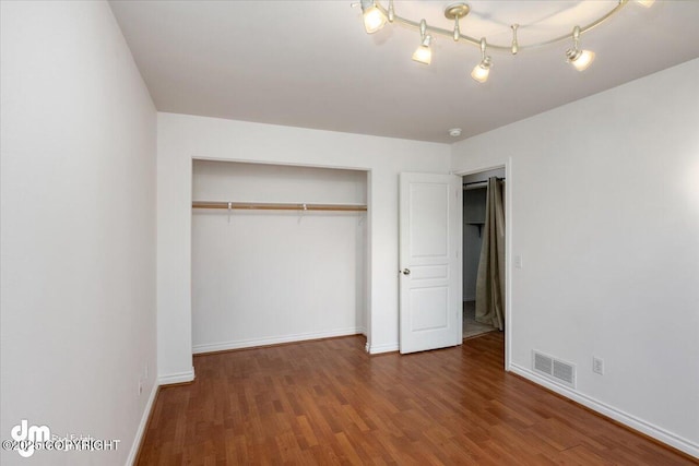 unfurnished bedroom featuring hardwood / wood-style floors and a closet