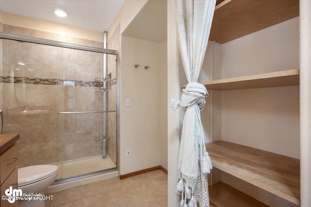 bathroom featuring toilet, a shower with door, and vanity