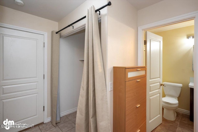 bathroom with toilet and tile patterned flooring