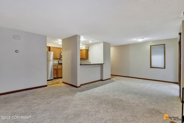 unfurnished living room with a textured ceiling and light carpet