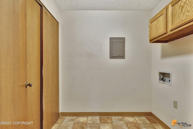 clothes washing area with a textured ceiling, washer hookup, electric panel, and cabinets