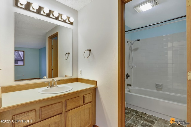 bathroom featuring a textured ceiling, bathtub / shower combination, and vanity