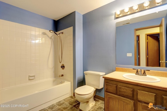 full bathroom with vanity, tiled shower / bath combo, and toilet