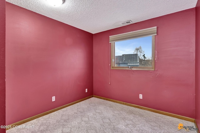 carpeted empty room with a textured ceiling