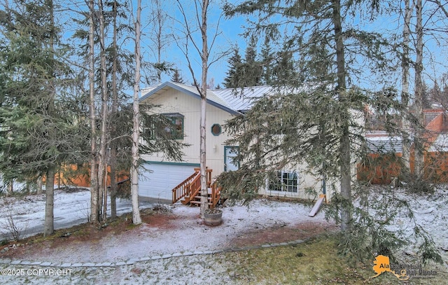 view of snowy exterior featuring a garage