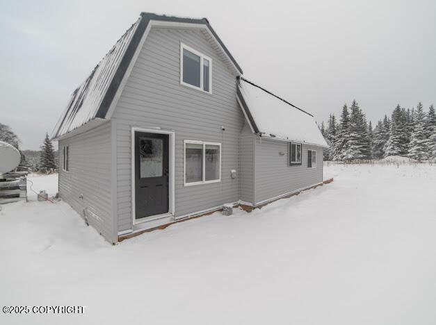 view of snow covered rear of property