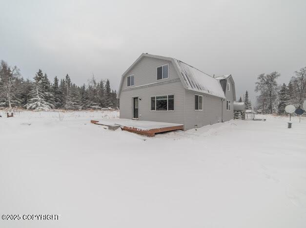 snow covered house featuring a deck