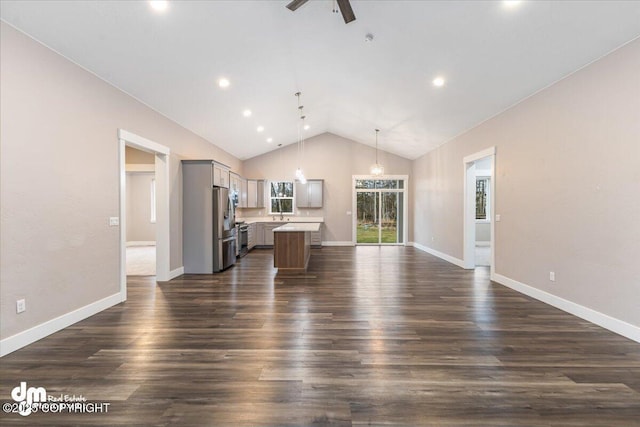 unfurnished living room featuring lofted ceiling, dark hardwood / wood-style floors, and ceiling fan