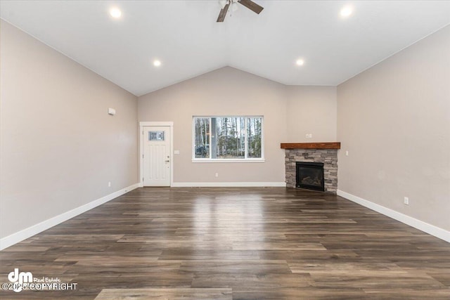 unfurnished living room with dark hardwood / wood-style floors, ceiling fan, lofted ceiling, and a stone fireplace