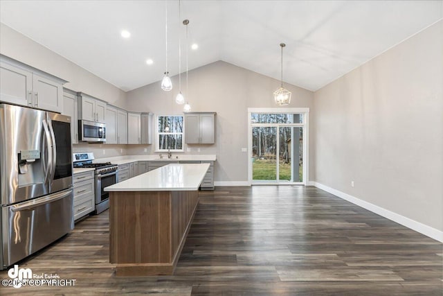 kitchen with a kitchen island, appliances with stainless steel finishes, pendant lighting, sink, and gray cabinetry