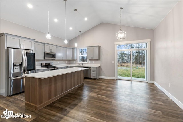 kitchen with gray cabinets, pendant lighting, high vaulted ceiling, a center island, and stainless steel appliances