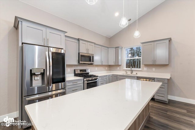 kitchen featuring pendant lighting, sink, gray cabinetry, stainless steel appliances, and a center island