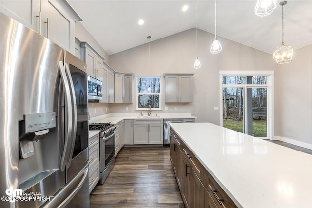 kitchen with appliances with stainless steel finishes, decorative light fixtures, sink, gray cabinetry, and dark hardwood / wood-style flooring