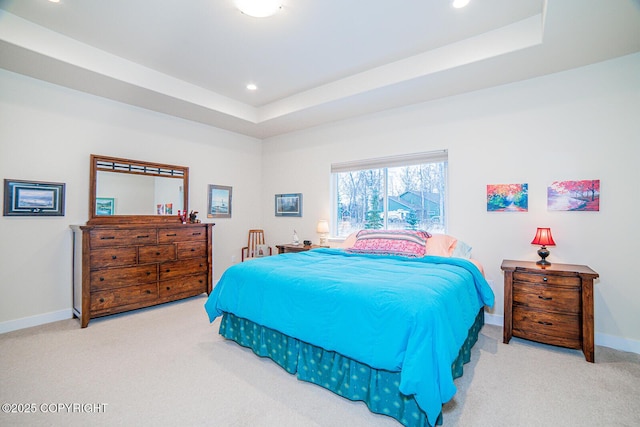 carpeted bedroom with a raised ceiling