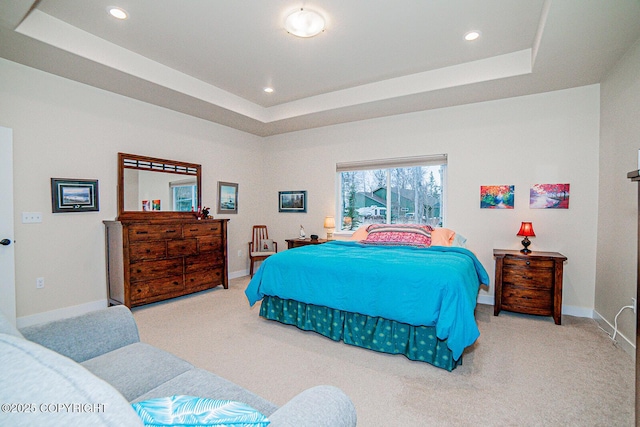 carpeted bedroom with a raised ceiling