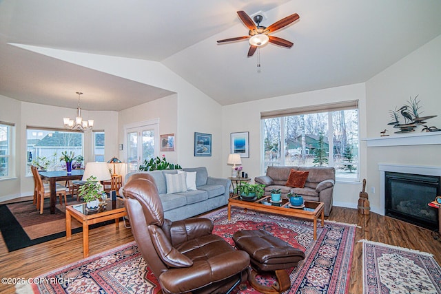 living room with hardwood / wood-style flooring, lofted ceiling, and ceiling fan with notable chandelier