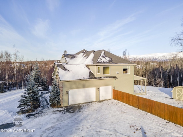 view of snowy exterior with a garage