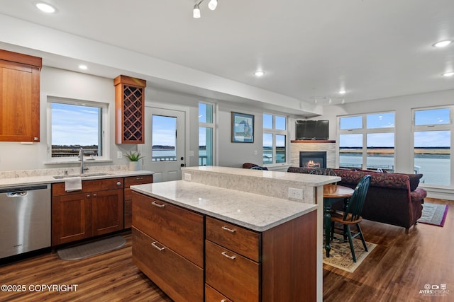 kitchen featuring dishwasher, sink, dark hardwood / wood-style flooring, and a center island