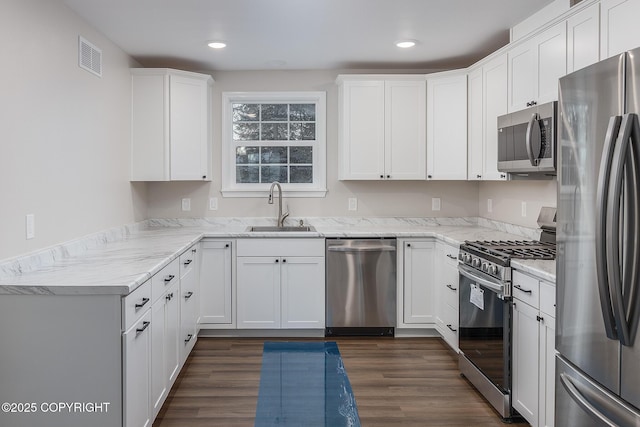 kitchen featuring light stone countertops, sink, white cabinetry, and stainless steel appliances