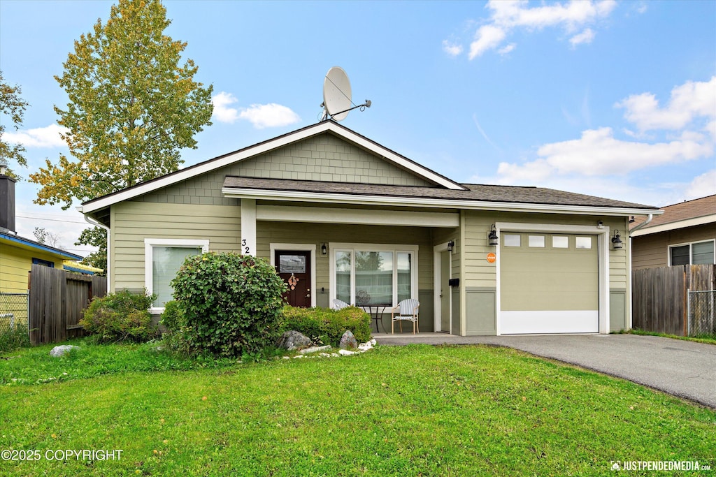 view of front facade featuring a garage, a front yard, and covered porch