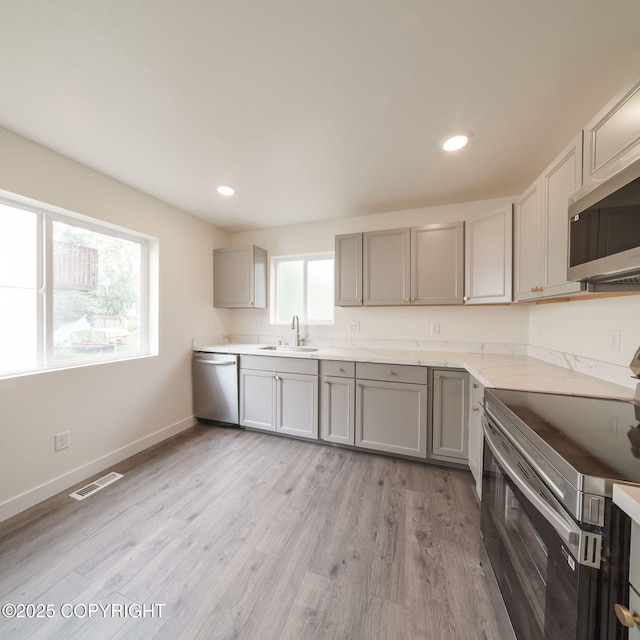 445 Idaho St, Anchorage, AK 99504 - kitchen with appliances with stainless steel finishes, gray cabinetry, light wood-style flooring, recessed lighting, and light stone countertops