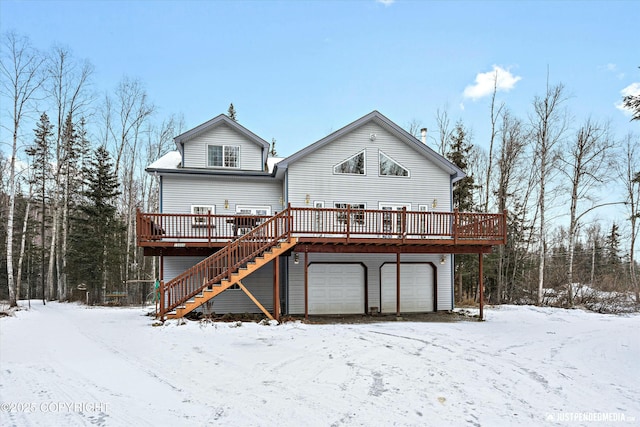 snow covered property featuring a wooden deck and a garage