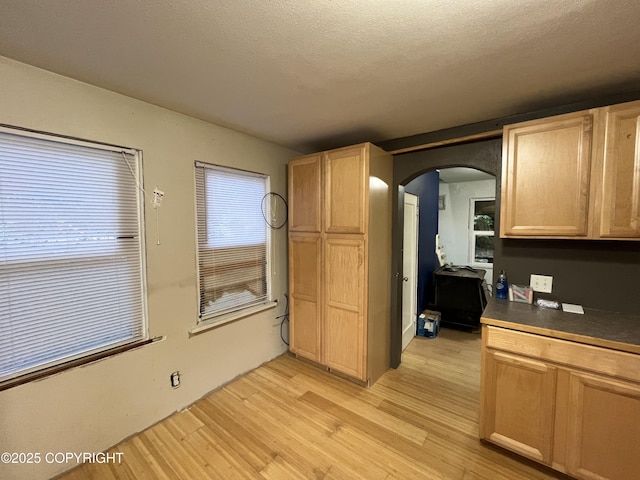 kitchen featuring a textured ceiling, light brown cabinets, and light hardwood / wood-style flooring