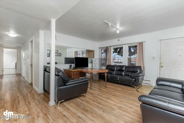 living room with a baseboard radiator, rail lighting, and light hardwood / wood-style floors