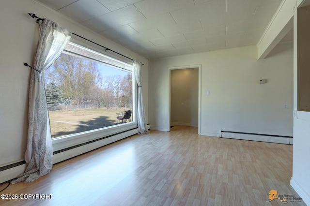 spare room featuring light wood-type flooring and a baseboard radiator