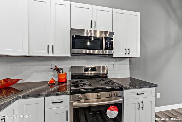 kitchen with backsplash, white cabinetry, and stainless steel appliances