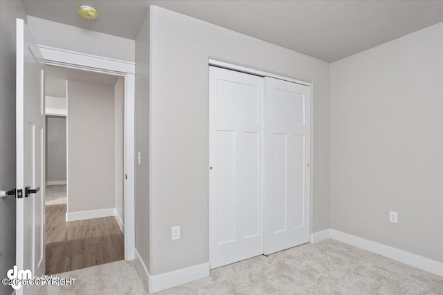 unfurnished bedroom featuring light carpet and a closet