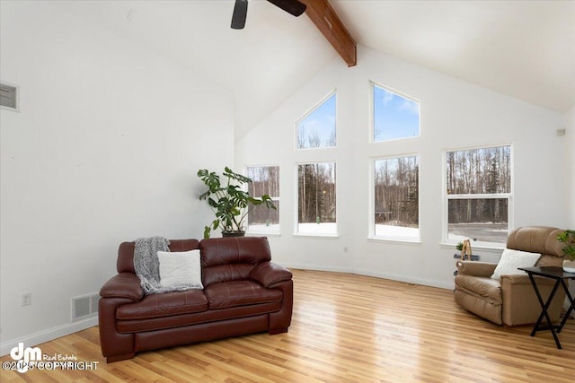 living room featuring beamed ceiling, light hardwood / wood-style flooring, and high vaulted ceiling