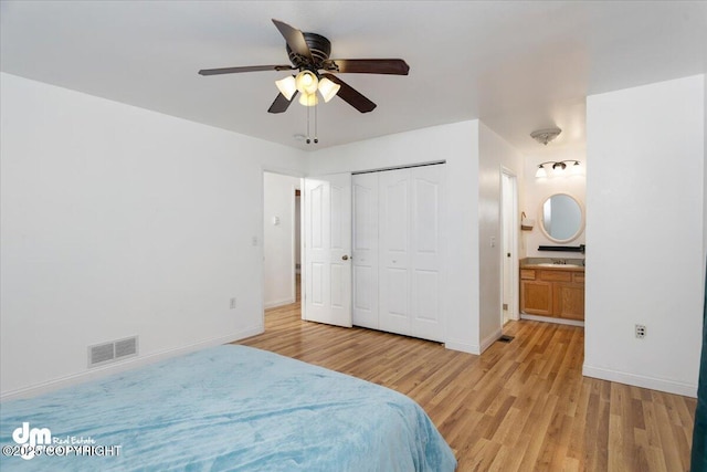 bedroom with ceiling fan, a closet, ensuite bath, and light hardwood / wood-style flooring