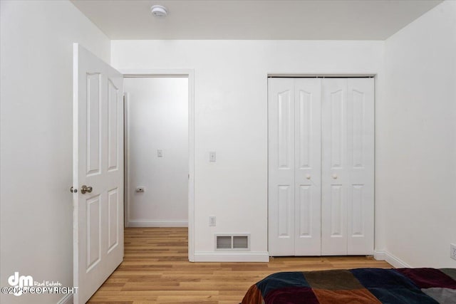 unfurnished bedroom with a closet and light hardwood / wood-style flooring