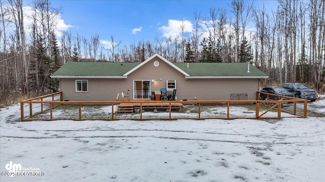 snow covered rear of property featuring a wooden deck