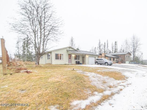 ranch-style home with a front lawn and a garage