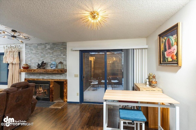 dining area with a large fireplace, dark hardwood / wood-style floors, and a textured ceiling