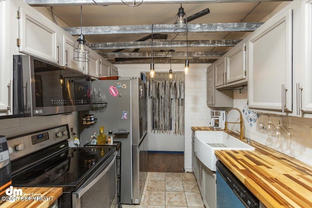 kitchen with pendant lighting, white cabinetry, sink, wooden counters, and stainless steel appliances