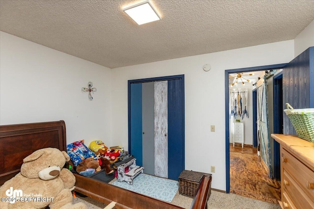 carpeted bedroom with a closet and a textured ceiling