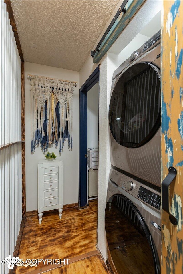 laundry area with stacked washer and dryer, dark hardwood / wood-style floors, and a textured ceiling