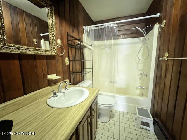 full bathroom with tile patterned floors, vanity, wood walls, and shower / tub combo