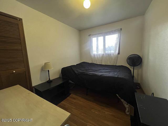 bedroom featuring dark hardwood / wood-style flooring and a closet