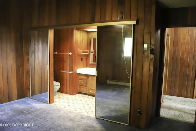 bathroom featuring wood walls and a baseboard radiator