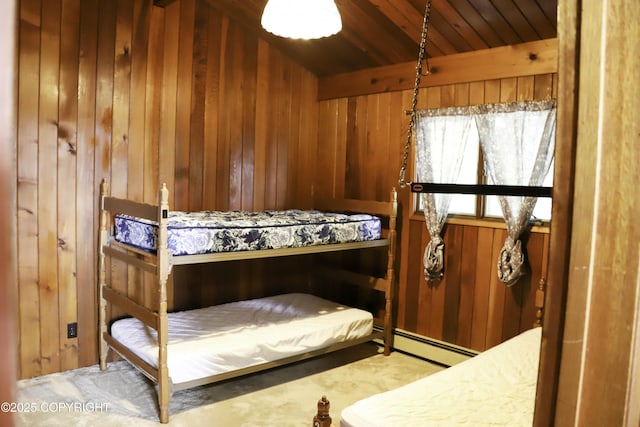 bedroom featuring a baseboard radiator, wood ceiling, and wooden walls