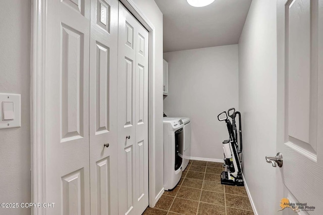 clothes washing area featuring cabinets and separate washer and dryer