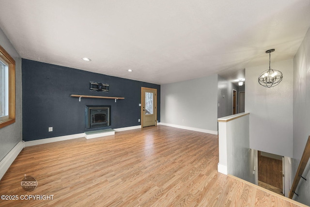 unfurnished living room featuring hardwood / wood-style flooring and an inviting chandelier