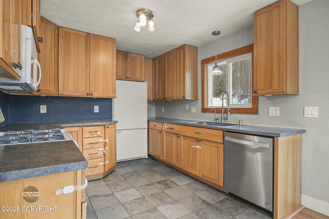 kitchen with decorative light fixtures, sink, and white appliances