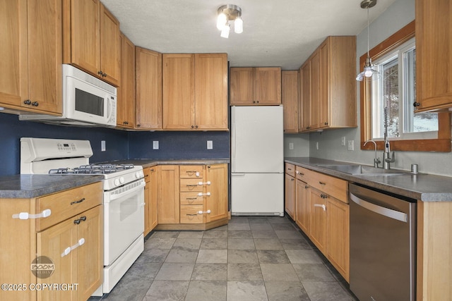 kitchen with hanging light fixtures, sink, and white appliances