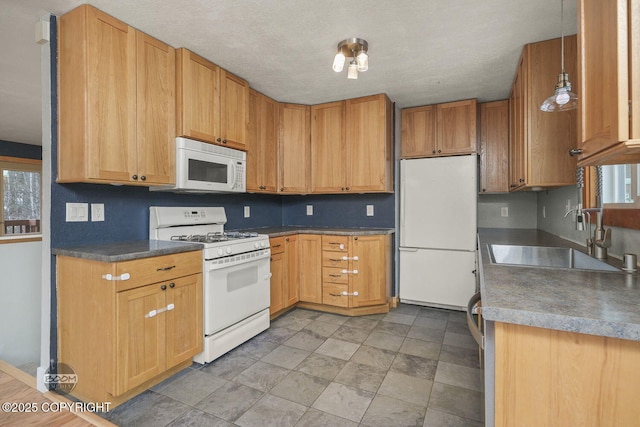 kitchen featuring a textured ceiling, decorative light fixtures, sink, and white appliances